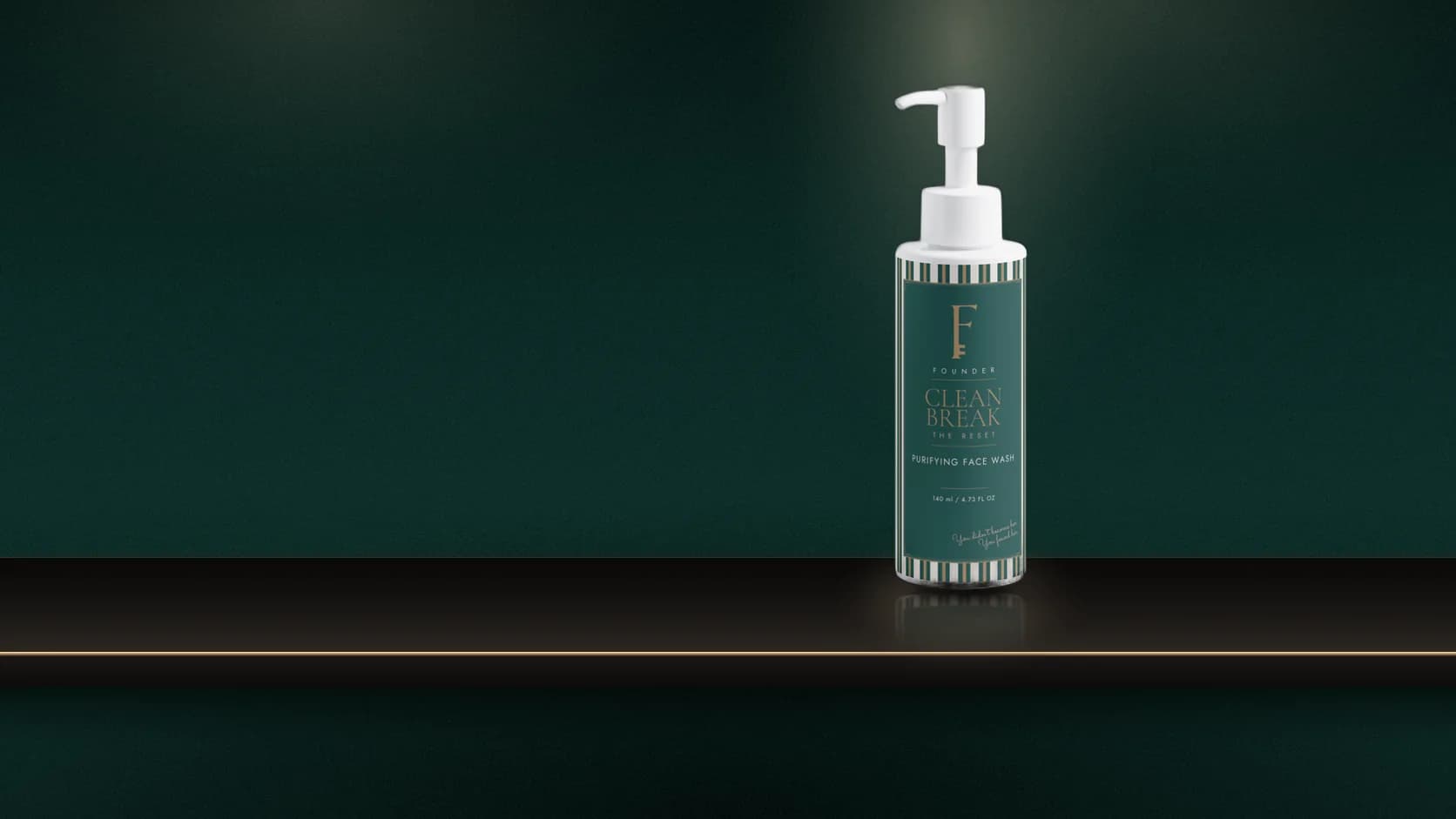 The Clean Break pump bottle and striped carton on a marble basin surround, water running from a brass tap, dark green panelling behind.