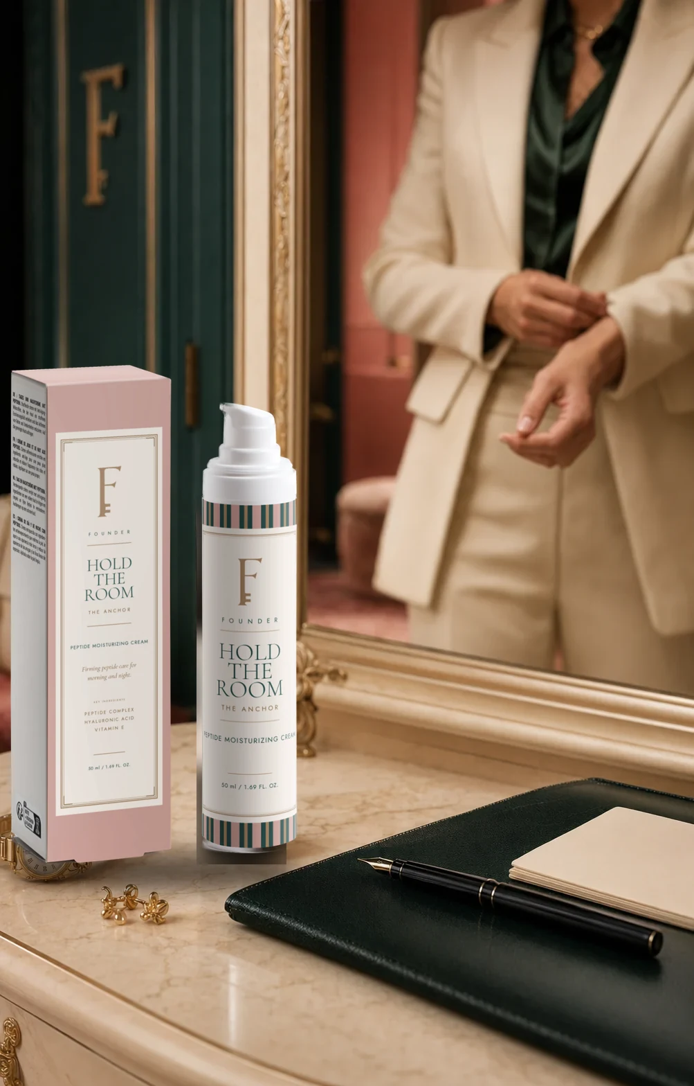 Hold the Room and its Desert Pink carton on a marble dressing table in front of a gilt mirror, a woman in a cream suit fastening her cuff in the reflection.