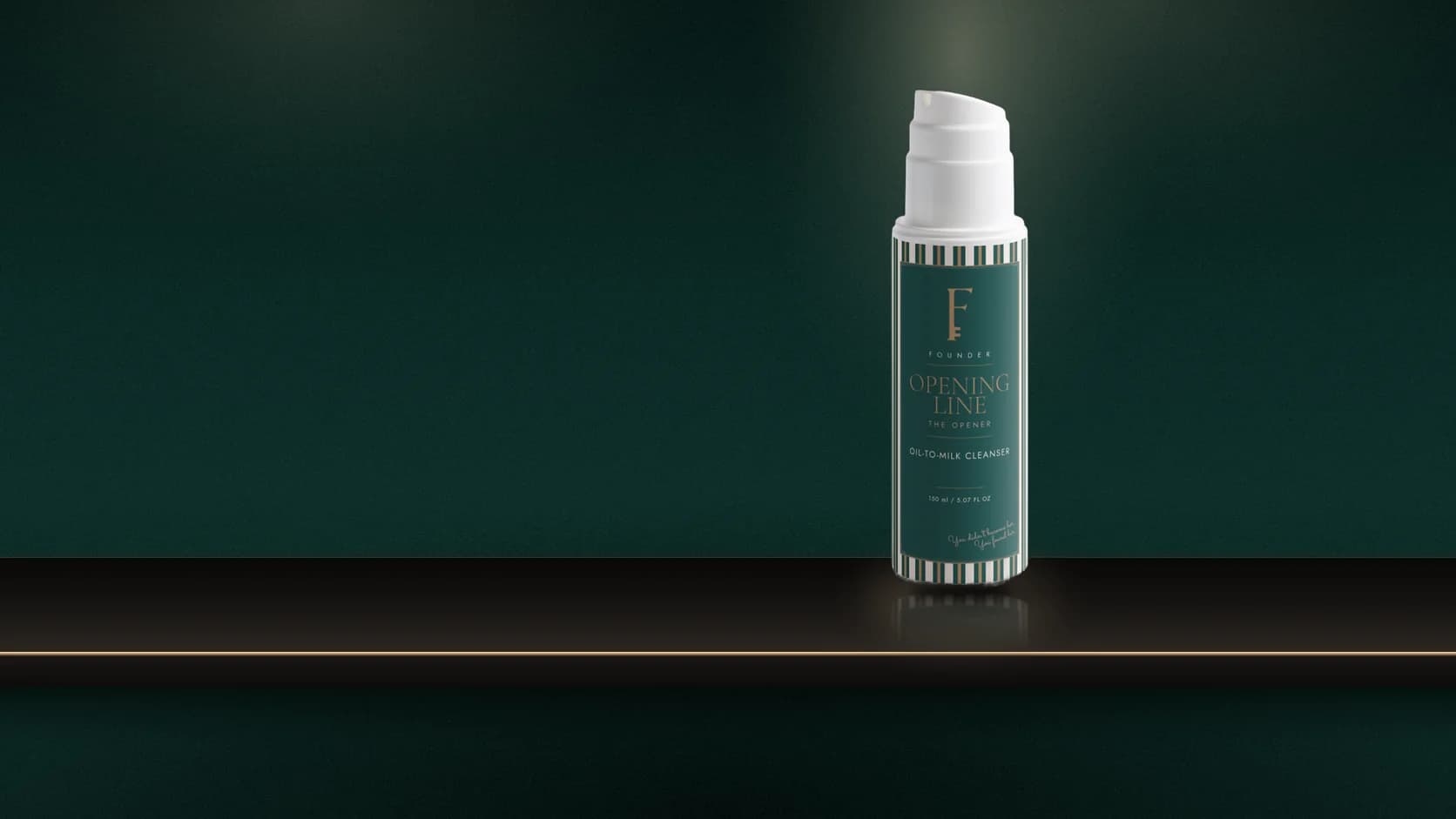 The Opening Line bottle and striped carton on a marble vanity ledge, a dish of cleanser beside them, dark green doors open onto a lit dressing room beyond.